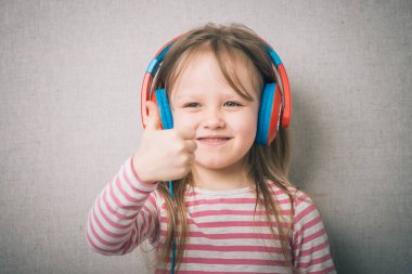 Güzel, sevimli, mutlu, kulaklıklı küçük kız.