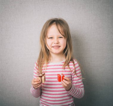 Elinde bir hediyeyle gülümseyen güzel bir kız..