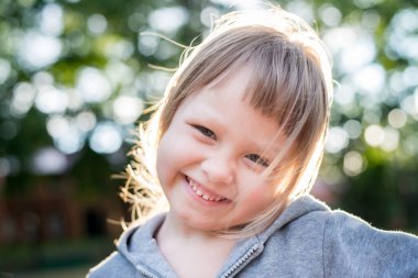 Parkta gülümseyen sevimli küçük kız.