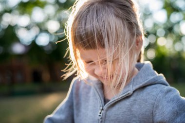 Parkta gülümseyen sevimli küçük kız.