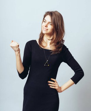 Güzel esmer bir kızın portresi yumruklarını sıkarak zafere seviniyor.