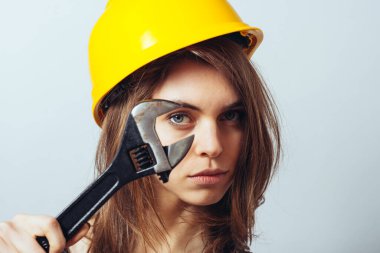 Kaskında büyük vida anahtarı olan güzel kadın mühendis.