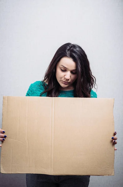 Vrouw Met Leeg Karton Een Grijze Achtergrond — Stockfoto