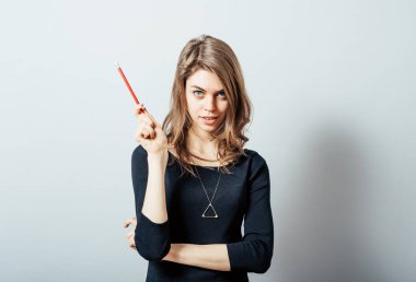 Güzel esmer kız bir tapınakta kalem tutmayı düşünüyor.