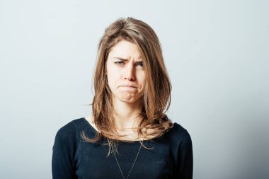Gri arka planda genç bir kadın