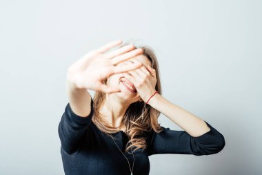 Yüzünü kapatan genç bir kadın.