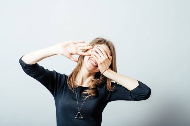 Yüzünü kapatan genç bir kadın.