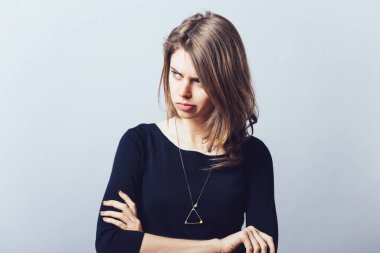 Closeup portrait displeased pissed off angry grumpy pessimistic woman with bad attitude, arms crossed looking at you Negative human emotion facial expression feeling