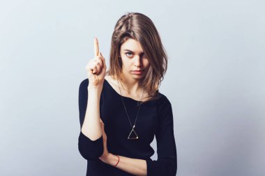 Çekici bir iş kadınının gri arka planda izole bir şekilde bulduğu işaret parmağı yukarı çözeltisi hakkında iyi bir fikri var. İnsan yüzü duygularını ifade eder vücut dili algısını.