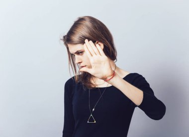 Gri arka planda durduğunu gösteren kızlar