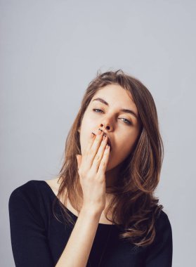 Kız gri arka planda esniyor