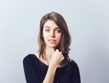 Gri arka planda poz veren kız