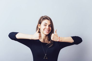 Kız başparmağını kaldırıyor.