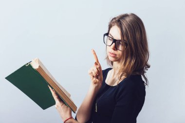 Gözlüklü kız kitap okuyor.