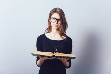 Gözlüklü kız kitap okuyor.