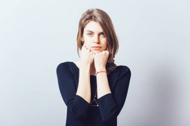 Gri arka planda izole bir şekilde el ele tutuşan güzel esmer kızın portresi.
