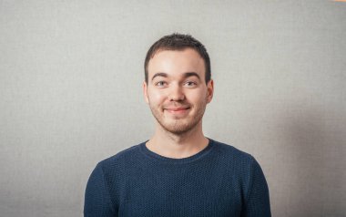 Gülümseyen adam. Gri bir arkaplanda.