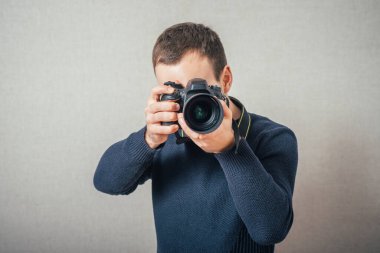 Dijital kameradaki adam fotoğrafları. Gri bir arkaplanda.