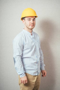 Sarı kasklı adam. Gri bir arkaplanda.