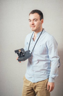 Retro fotoğraf makinesi olan yakışıklı bir genç. 