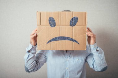 Mutsuz bir gülümseme kartı olan genç bir adam.