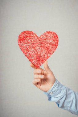 Genç adam bir kalp tutuyor.