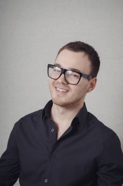 Gülümseyen gözlüklü sıradan bir adamın portresi.