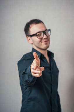 Adam parmağını ileri uzattı. Gri bir arkaplanda.
