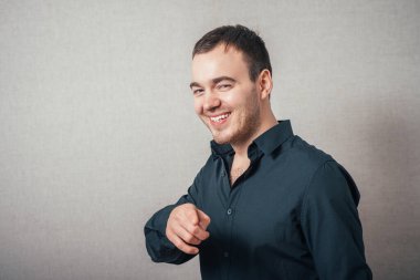 Adam parmağını ileri uzattı. Gri bir arkaplanda.