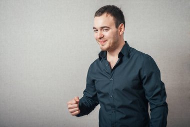 Bir adam ilk intikamı gösterir. Gri bir arkaplanda.