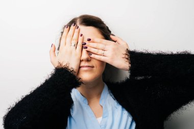 Kız elleriyle gözlerini kapatıyor.