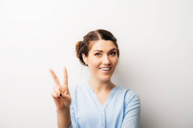 Bir kadın zafer jesti gösterir. Beyaz bir arkaplanda izole edilmiş