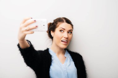Selfie telefonunun fotoğrafını çeken kadın. Beyaz bir arkaplanda izole edilmiş