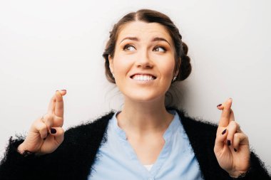 Kadın şans dilemek için dua etti, bir dilek tut. Beyaz bir arkaplanda izole edilmiş