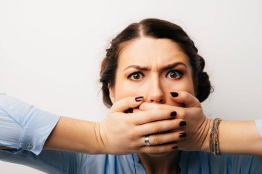 Güzel esmer kız elleriyle ağzını kapatıyor.