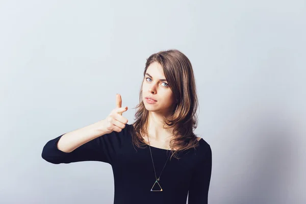 Vrouw Wijsvinger Naar Camera Naar Voren Een Grijze Achtergrond — Stockfoto