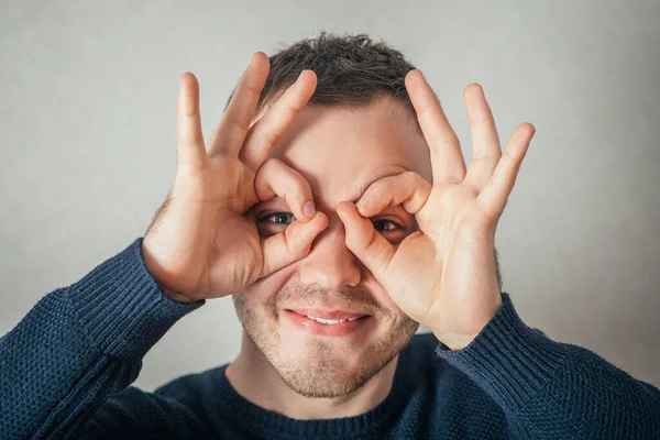 Man Tittar Genom Glasögonen Fingrarna Grå Bakgrund — Stockfoto