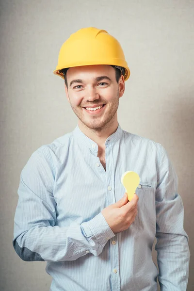 Hombre Con Casco Amarillo Sosteniendo Una Pegatina Forma Bombillas Sobre —  Fotos de Stock