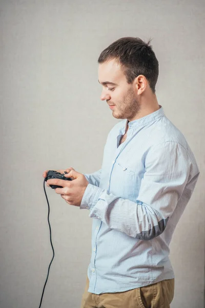 快乐的年轻人 身穿衬衫 手持电玩操纵杆 摆出一副得意洋洋的架势 — 图库照片