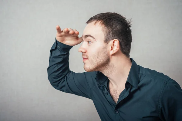 Homem Olha Para Frente Com Mão Testa Fundo Cinza — Fotografia de Stock