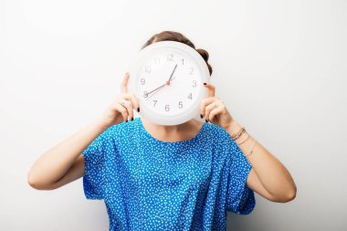Kafasını tutan kocaman saati olan güzel bir kız.