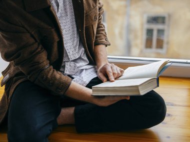 Genç adam kitap okuyor.