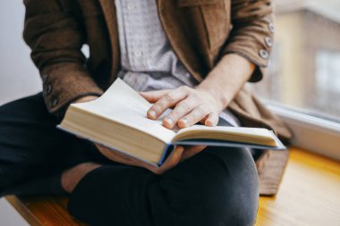 Genç adam kitap okuyor.