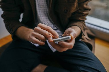 Genç adam cep telefonundan numara çeviriyor