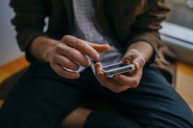 Genç adam cep telefonundan numara çeviriyor