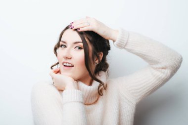 Başı ağrıyan kadın elleriyle başını tutuyor..