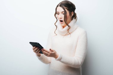 Gri arka planda izole edilmiş tablet bilgisayar kullanan mutlu genç kadın