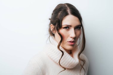 Kapanış portresi, üzgün genç bir kadın, migreni olan bir çalışan, gerilim baş ağrısı, gri duvar arkaplanı. İnsan yüzü ifadesi duygusal tepki, tutum