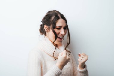 Beyaz arka planda yumrukları olan esmer bir kız.