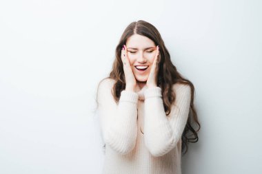 Güzel, uzun saçlı kız yüzü, beyaz arka planda Asyalı gözleri ile oynaşıyor.